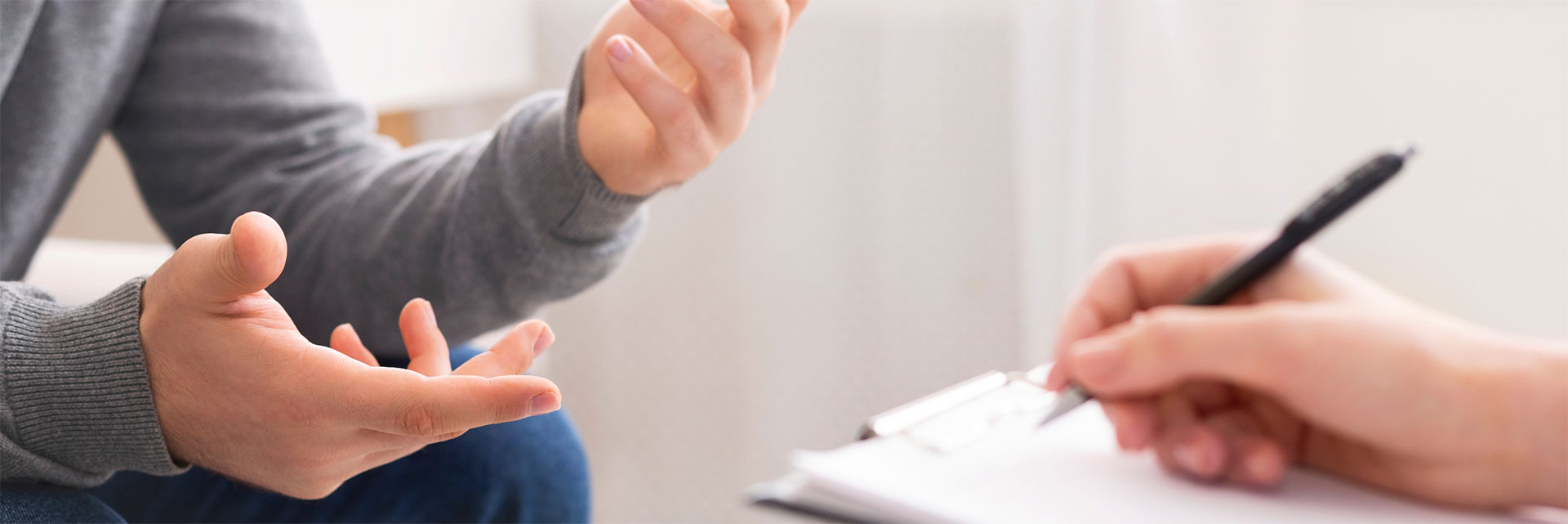 Dottoressa che prende appunti mentre il paziente parla e gesticola