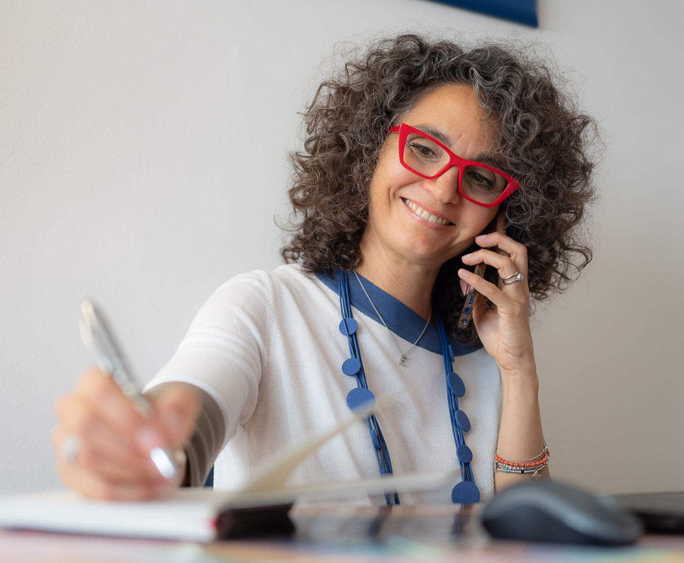 Elena in ufficio al telefono mentre scrive